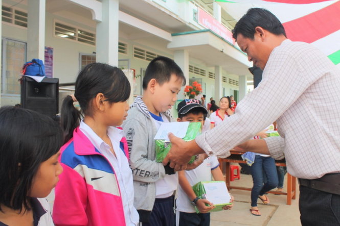 Đại diện địa phương trao học bổng (500.000đ và dụng cụ học tập) cho các em nghèo vượt khó - Ảnh: Khoa Nguyễn