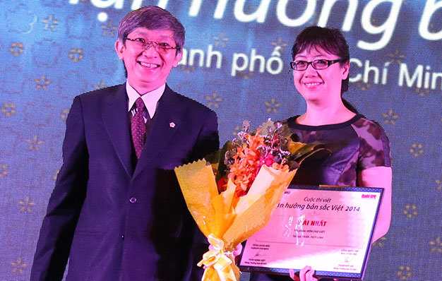 Ông Trần Hùng Việt - tổng giám đốc Saigontourist, đồng trưởng ban tổ chức - trao giải nhất cho chị Trần Thùy Linh, người đoạt giải nhất cuộc thi viết với bài “Hồn chợ Việt” - Ảnh: Tiến Long