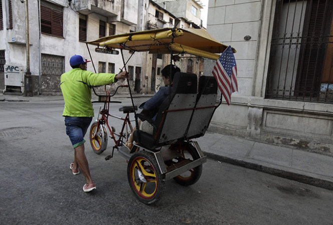 Một xe lôi chở khách ở Havana có cắm cờ Mỹ. Ảnh: Reuters