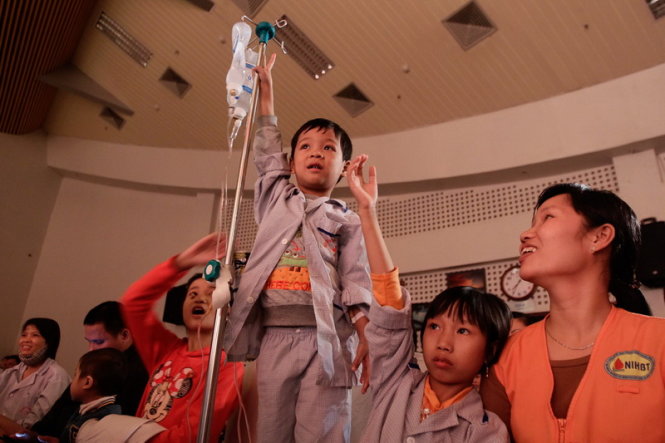 Mặc dù đang phải truyền dịch nhưng bệnh nhi Nguyễn Dương Hưng (6 tuổi) vẫn hào hứng giơ tay trả lời câu hỏi của chương trình, Hưng đang điều trị căn bệnh thiếu máu huyết tán - Ảnh: Nguyễn Khánh