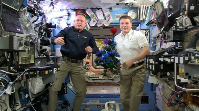 Hai phi hành gia “lơ lửng” trên ISS cầm cây thông Noel gửi lời chúc Giáng sinh - Ảnh:nbcnews.com