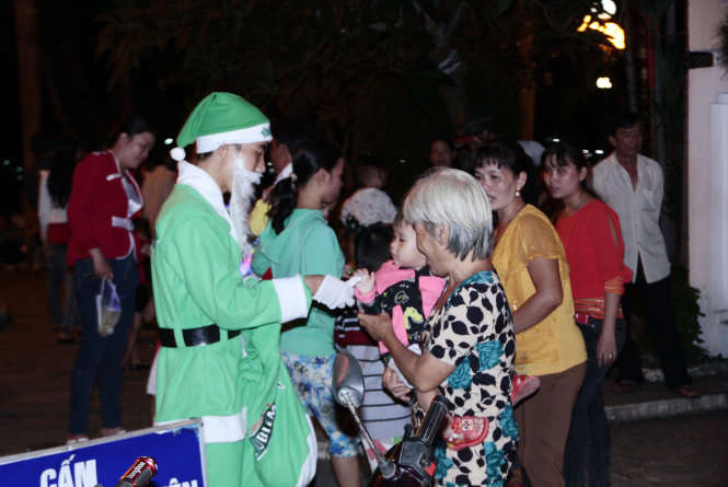 Ông già Noel phát quà cho trẻ em ở bến Ninh Kiều tối 24-12 - Ảnh: Chí Quốc