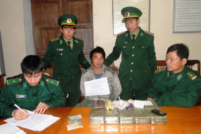 Đối tượng Hạ Bá Cu cùng tang vật 20 bánh heroin bị lực lượng biên phòng Nghệ An bắt giữ - Ảnh: Hải Thượng