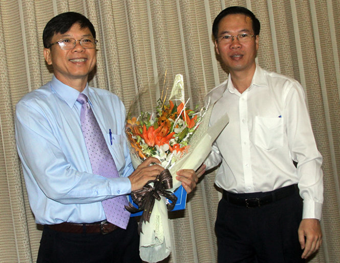 Ông Võ Văn Thưởng, phó bí thư thường trực Thành ủy tặng hoa chúc mừng phó giáo sư-tiến sĩ Nguyễn Văn Trình - Ảnh: Quang Khải