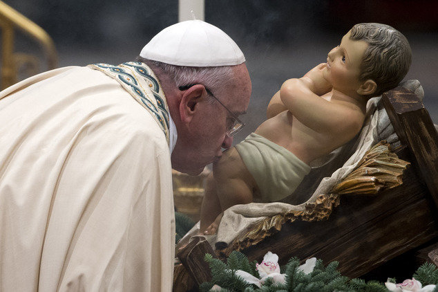 Giáo hoàng Francis hôn lên bức tượng chúa Giê-su lúc mới chào đời tại nhà thờ Thánh Peter, Vatican trong thời khắc giao thừa 2014-2015 - Ảnh: AP