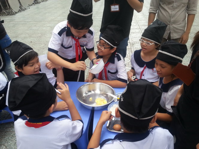 Học sinh Trường tiểu học Nguyễn Bỉnh Khiêm (Q.1, TP.HCM) làm bánh trong buổi ra mắt CLB “Khéo tay hay làm” - Ảnh: Xuân Bình