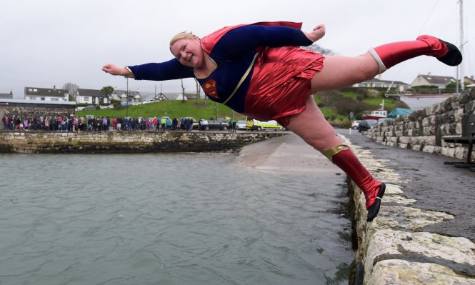 “Superwoman” Angela McClements tung mình xuống vùng nước bãi biển cảng Carnlough (Bắc Ireland) - Ảnh: Getty Images