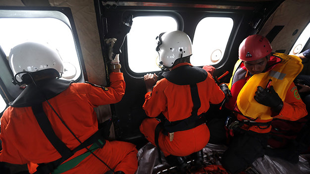 Nhân viên cứu hộ Indonesia quan sát mặt biển Java từ trực thăng - Ảnh: Reuters