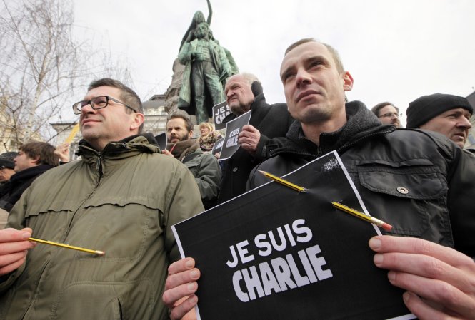 Các phóng viên tham gia phút mặc niệm nạn nhân vụ tấn công tòa soạn Charlie Hebdo tại Slovenia mang theo bút và biểu ngữ 