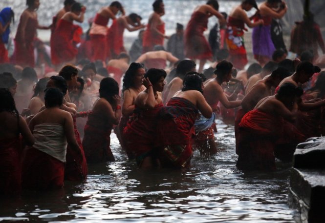 Phụ nữ Nepal tắm dưới dòng sông thánh cầu nguyện cho gia đình hạnh phúc - Ảnh: Reuters