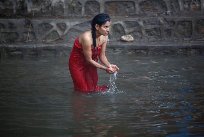 Một thiếu nữ tắm thánh sông Salinadi - Ảnh: Reuters