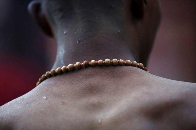 Một tín đồ Hindu đeo chuỗi hạt tại lễ tắm thánh Swasthani Brata Katha - Ảnh: Reuters
