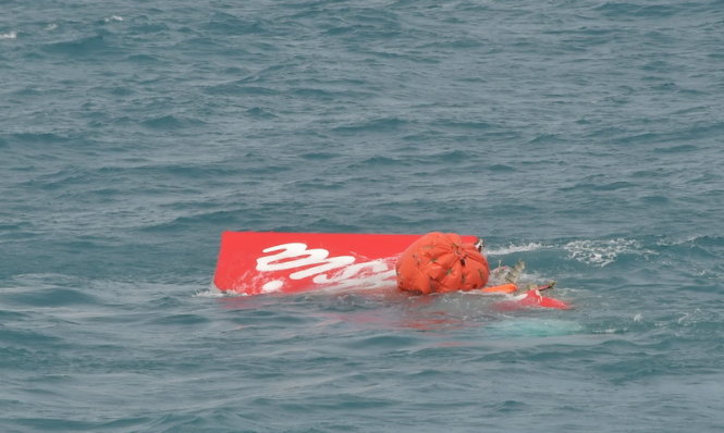 Phần đuôi màu đỏ của chiếc máy bay QZ8501 nổi lên khỏi mặt biển ngày 10-1 - ảnh: Reuters