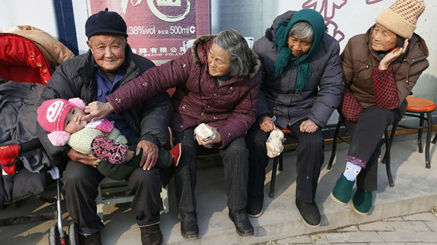 Một đứa trẻ Trung Quốc được nội ngoại chăm chút - Ảnh: Reuters