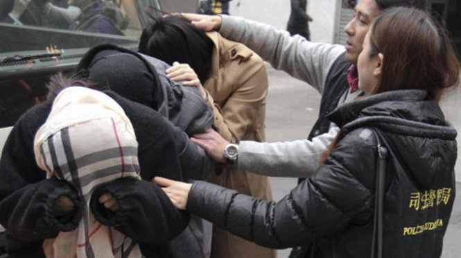 Các cô gái được cho là làm gái dâm ở Macau bị bắt đến đồn cảnh sát để thẩm vấn - Ảnh: SCMP