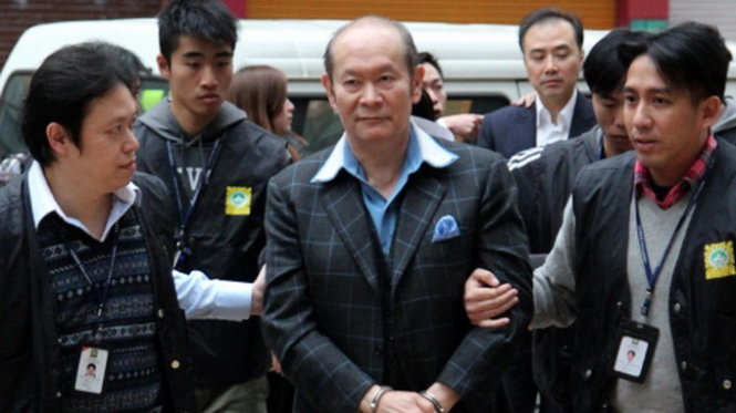 Ảnh: Alan Ho (giữa) bị cảnh sát giải đi trong vụ truy quét gái mại dâm ở Ma Cau  Ảnh:SCMP