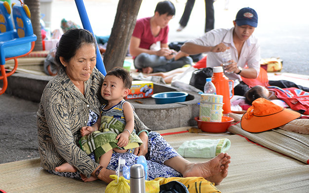 Bé Lương Gia Bảo (3 tuổi, quê Bình Định) và bà ngoại phải ra ngoài gốc cây trong khuôn viên Bệnh viện Nhi Đồng 1, TP.HCM nằm vì nhiều giường bệnh tại bệnh viện đã quá tải - Ảnh: Hữu Khoa