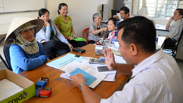 Người dân đăng ký mua bảo hiểm y tế hộ gia đình tại phường Hiệp Phú, Q.9 (TP.HCM) - Ảnh: Hữu Khoa