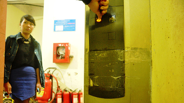 Hình ảnh nút điều khiển trong buồng thang bị bong phải dùng băng keo dán dính lại (ảnh chụp ở khu tái định cư Trung Hòa - Nhân Chính) - Ảnh: Q.Thế