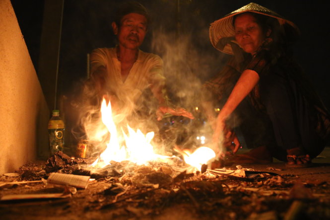 Vợ chồng ông Nguyễn Văn Tuyết đốt lửa sưởi ấm chờ trời hửng sáng để đi nhặt ve chai