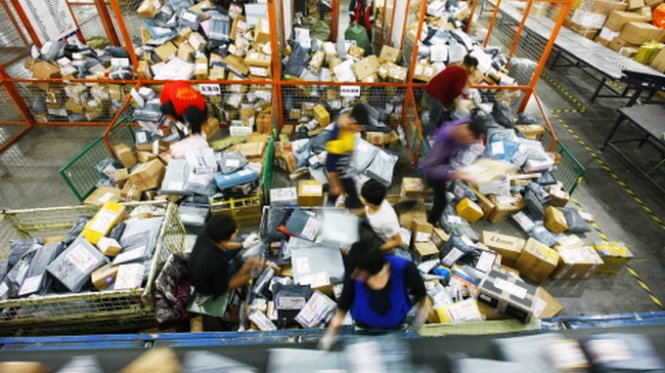 Hàng hóa đang được đóng gói, phân loại và đem giao cho khách hàng mua sắm trực tuyến ở Trung Quốc -  Ảnh:Xinhua