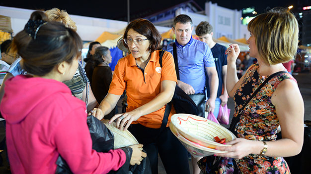 Các du khách người Ukraine rộn ràng chọn mua nón lá tại chợ đêm