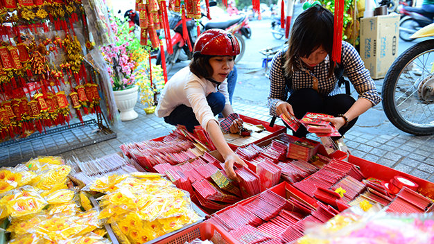 Người dân chọn mua đồ trang trí tết như: bao lì xì, câu đối chúc tết,hoa mai giả…tại một cửa hàng trên đường Hai Bà Trưng, Q.3, TP.HCM chiều 1-2 - Ảnh: Quang Định