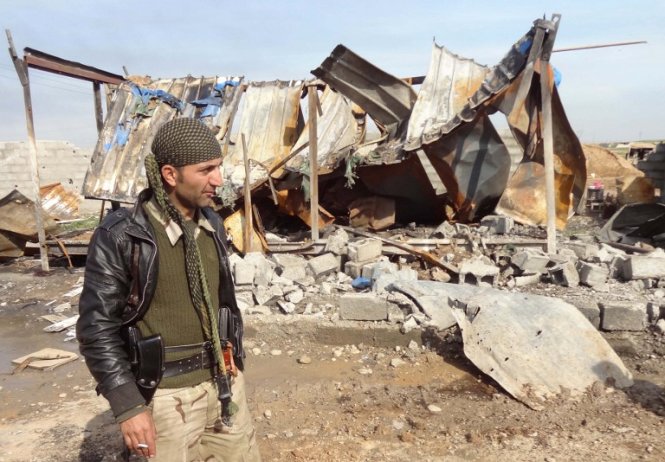 Một binh sĩ người Kurd đứng trước đống đổ nát gần thành phố Kirkuk, nơi lực lượng này vừa giành lại từ tay IS. Ảnh: AFP