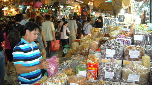 Người bán hàng ở một gian hàng mứt, đồ khô tại chợ Bến Thành luôn tay đóng gói bánh mứt, thịt khô cho khách Việt Kiều mang ra nước ngoài ăn tết