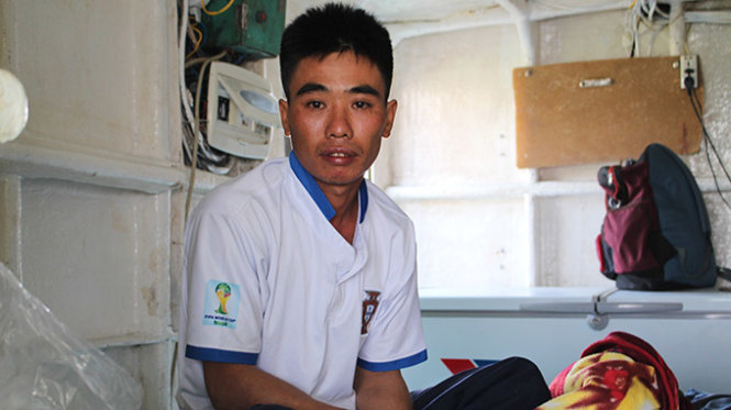 Ngư dân Nguyễn Tiến Trung với khuôn mặt thất thần trong khoang tàu trước khi được đưa lên bờ - Ảnh: Trần Mạnh