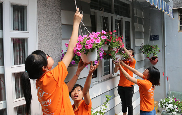 Những lẵng hoa rạng rỡ sắc xuân được nhóm “ôsin” sinh viên phụ giúp chủ nhà treo lên