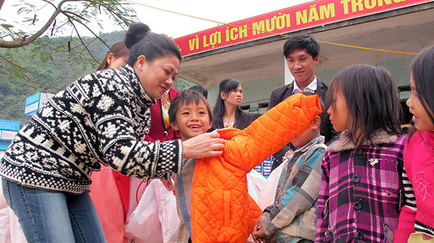 Bà Đỗ Thị Kim Liên, tổng lãnh sự danh dự Nam Phi tại TP.HCM, trao quà, mặc những áo ấm mới cho học sinh xã Hua Bum, huyện Nậm Nhùn (Lai Châu) - Ảnh: Đ.Bình