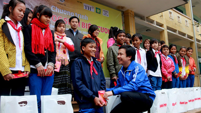 Anh Vũ Huy Nam, trưởng ban thanh niên trường học tỉnh đoàn Quảng Trị hỏi thăm, trao quà cho em Hồ Văn Đào, học sinh có đôi chân bị khuyết tật - Ảnh: Ngọc Hiển
