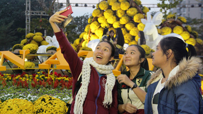 Các bạn trẻ Đà Nẵng cùng nhau chụp hình ở khu vực đường hoa xuân Đà Nẵng - Ảnh: Phan Thành