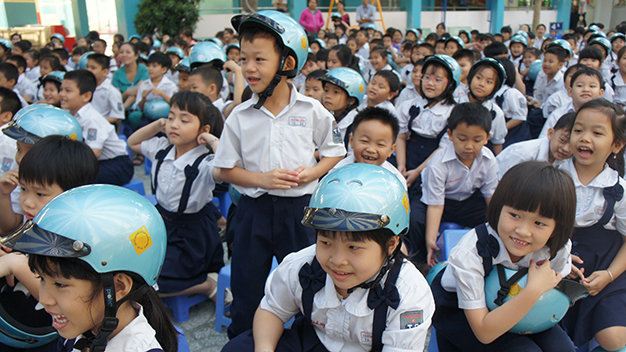Các em học sinh Trường tiểu học Trương Định thích thú với các hoạt động tìm hiểu, kết thân với “người bảo vệ dễ thương” là mũ bảo hiểm - Ảnh: Hải Thi