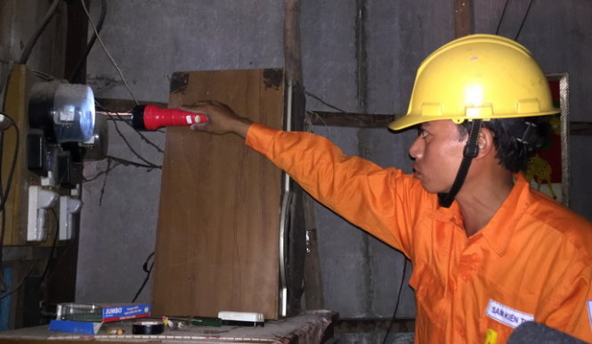 Nhân viên Công ty điện lực Kiên Giang chốt chỉ số điện tại nhà dân trước thời điểm đón dòng điện từ điện lưới quốc gia trưa 11-2 - Ảnh: N.Triều