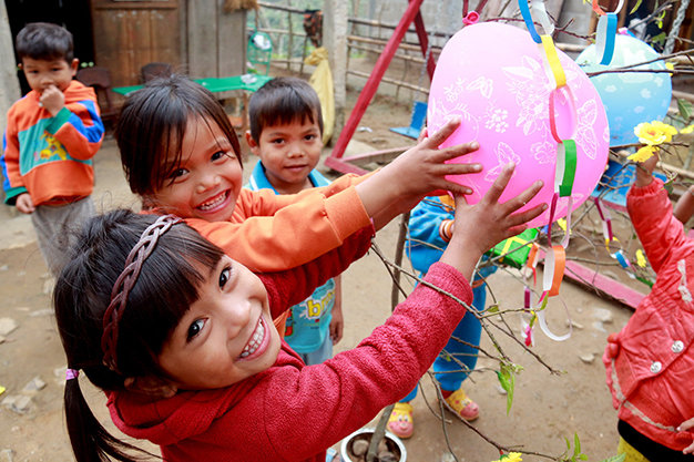 Các em vây quanh cây mai giả giữa sân trường - Ảnh: Ngọc Hiển