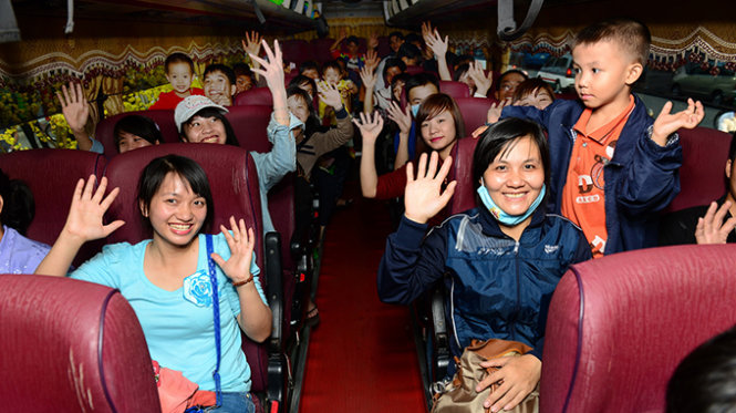 Công nhân đang làm việc tại TP.HCM có quê tỉnh Hà Tĩnh tươi cười trước giờ xe lăn bánh trong lễ chuyến xe công nhân tại Nhà văn hóa Thanh niên, Q.1, TP.HCM chiều 12-2 - Ảnh: Quang Định