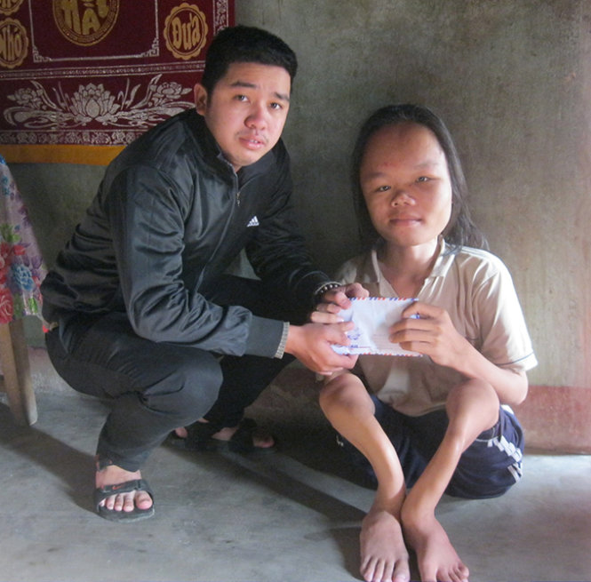 Đại diện báo Tuổi Trẻ trao số tiền 2,7 triệu đồng cho Sơn “thủy tinh” - Ảnh: Thanh Ba