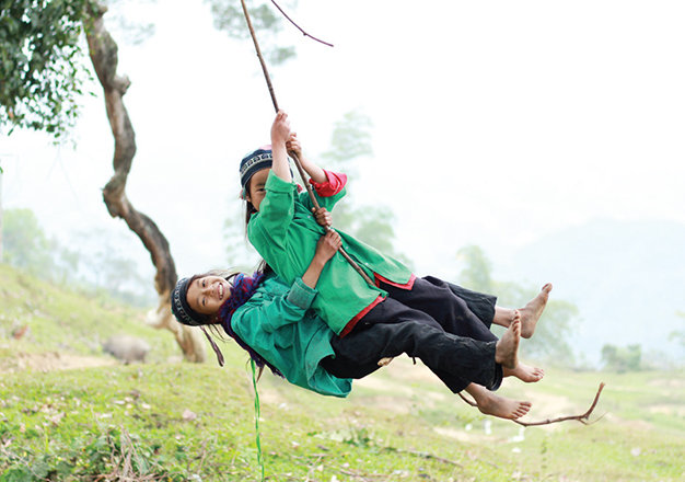 “Trên đường đi bản Lùng Cẩu về, tôi bắt gặp những trẻ em người La Chí đang bám đu những rễ đa cổ thụ ven đường. Tôi dừng xe lại và chụp khoảnh khắc vui chơi của các em. Các em này đã nhận được ảnh từ hôm trước nên rất thoải mái cho tôi chụp hình” -  Hùng chia sẻ