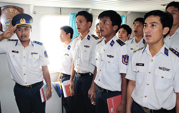 Chiến sĩ tàu cảnh sát biển 4034 hát quốc ca trong lễ kết nạp đảng viên mới trên tàu ngày 16-7-2014 - Ảnh: Hà Bình