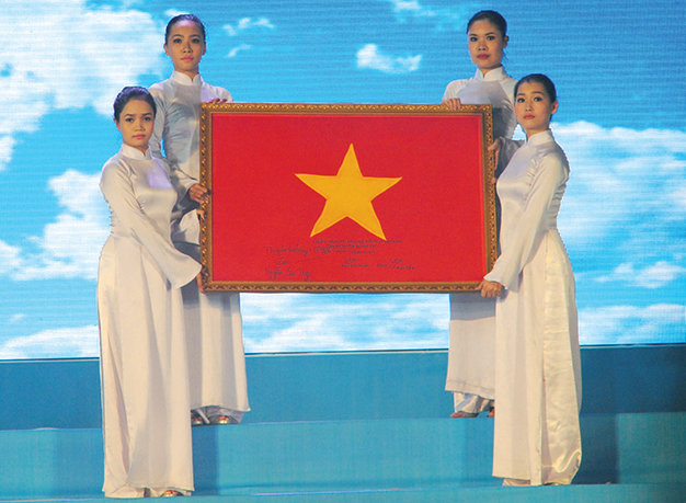 Các bạn trẻ với lá cờ mang về từ Hoàng Sa tại chương trình “Linh thiêng Tổ quốc Việt Nam” - Ảnh: Tự Trung
