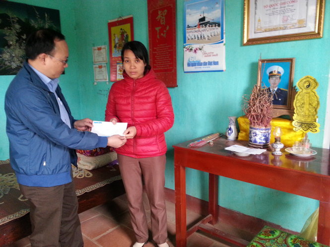 Đại diện báo Tuổi Trẻ tại Thanh Hóa (bên trái ảnh) trao quà Tết của bạn đọc báo cho chị Lại Thị Huế- vợ liệt sỹ Phạm Quang Trung- Ảnh: Hà Đồng