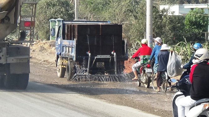 Xe tưới nước ở những phần đường thi công chưa xong để hạn chế bụi bẩn