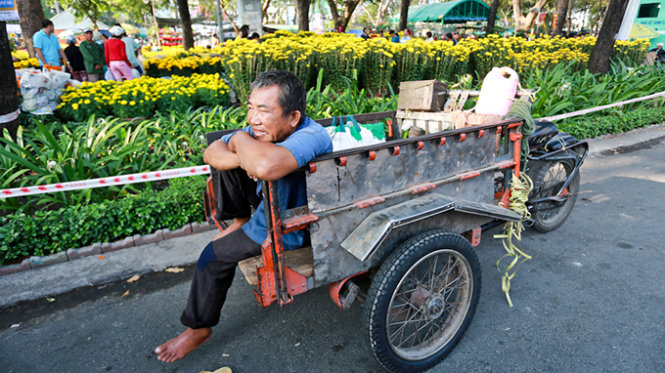 Hoa quả tết không bán được kéo theo nghề chở hoa quả thuê cũng ế ẩm. Trong ảnh: ông Nguyễn Văn Châu (ở Q.4, TP.HCM) chờ khách thuê chở hoa quả tết trên đường Trần Hưng Đạo - Ảnh: Tiến Thành