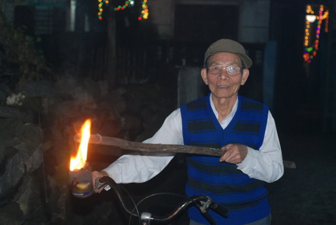 Một cụ ông rước lửa về sưởi ấm nhà mình ngày tết - Ảnh: Quốc Nam