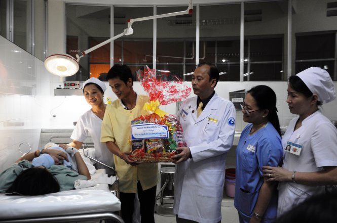 Bác sĩ Lê Quang Thanh, giám đốc bệnh viện Từ Dũ cùng kíp trực tặng quà và chúc mừng các gia đình có con sinh vào những thời khắc đầu tiên của năm mới. Ảnh: Đình Khánh