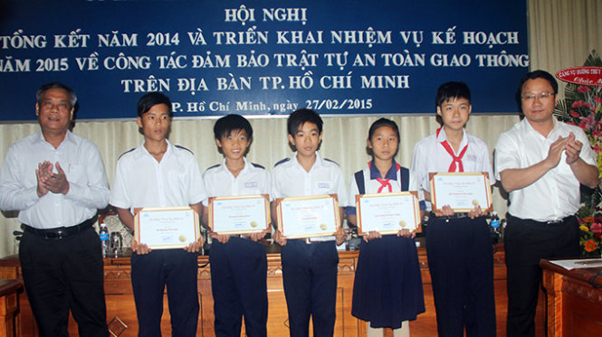 Ông Khuất Việt Hùng – phó chủ tịch UB an toàn giao thông quốc gia (bên phải) trao học bổng cho các học sinh tại hội nghị - Ảnh: Quang Khải