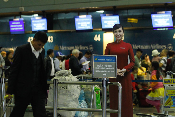 Hành khách làm thủ tục bay trong quầy thủ tục của hãng hàng không quốc gia VN Vietnam Airlines tại nhà ga hành khách T1 sân bay quốc tế Nội Bài (Hà Nội) - Ảnh: Nguyễn Khánh