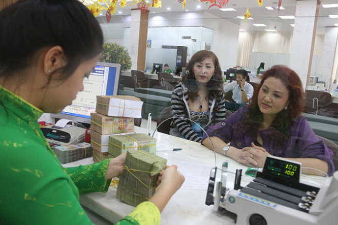 Khách hàng giao dịch tại Ngân hàng Vietcombank trên đường Võ Văn Kiệt (Q.1, TP.HCM) ngày 9-3 - Ảnh: Tiến Long